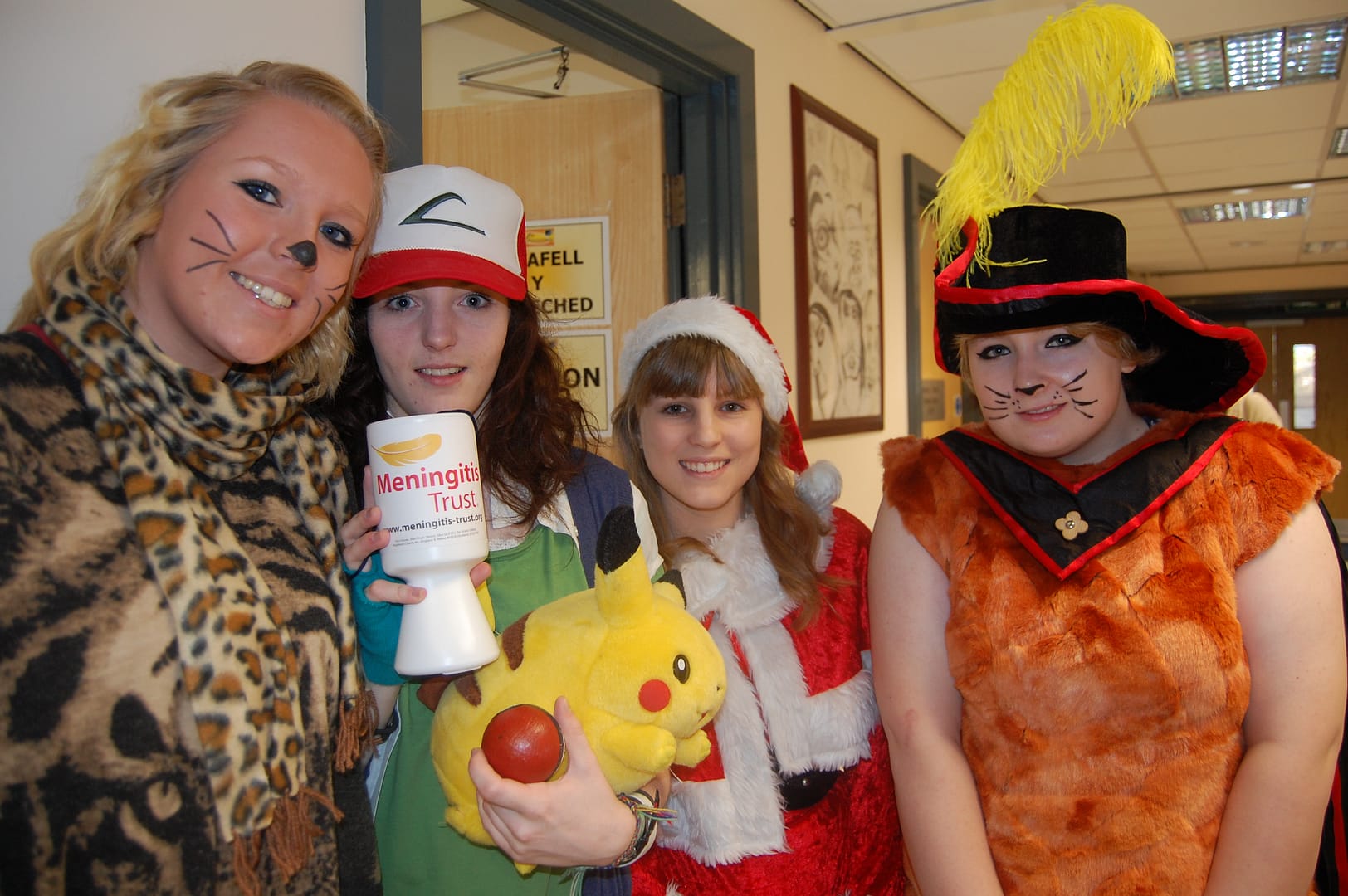 Four sixth form students in colourful costumes posing for Children in Need fundraising.
